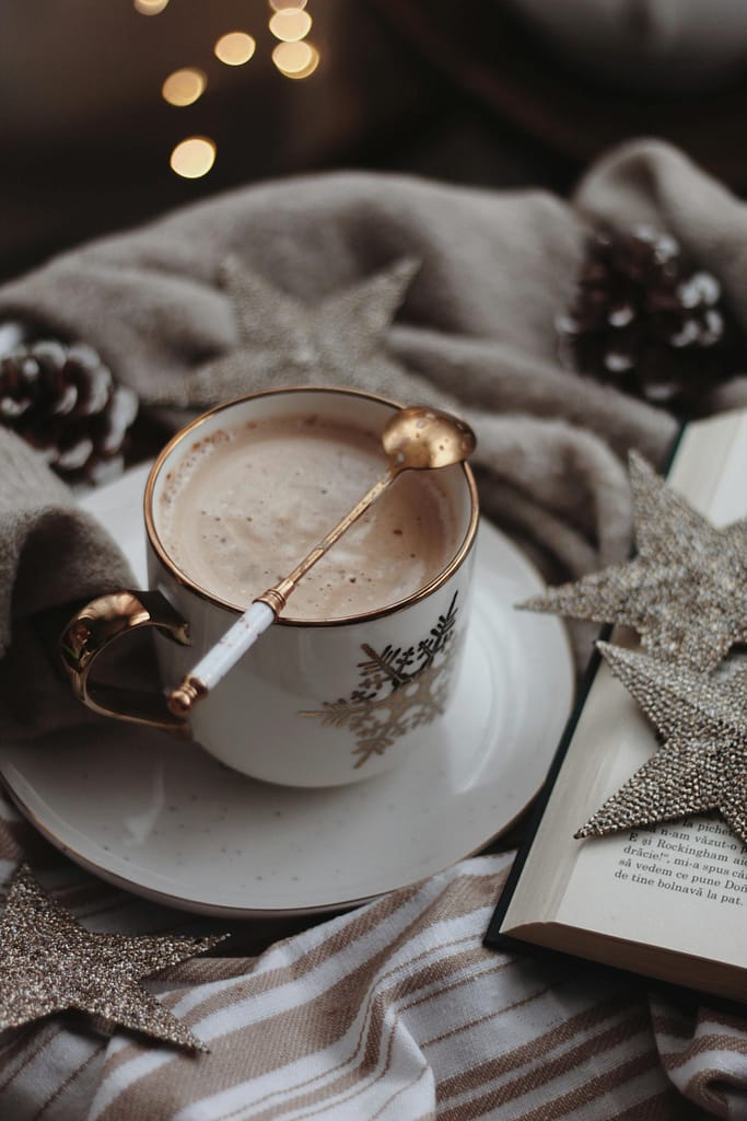 Holiday Reading : a cup of coffee with a spoon on a saucer and a book